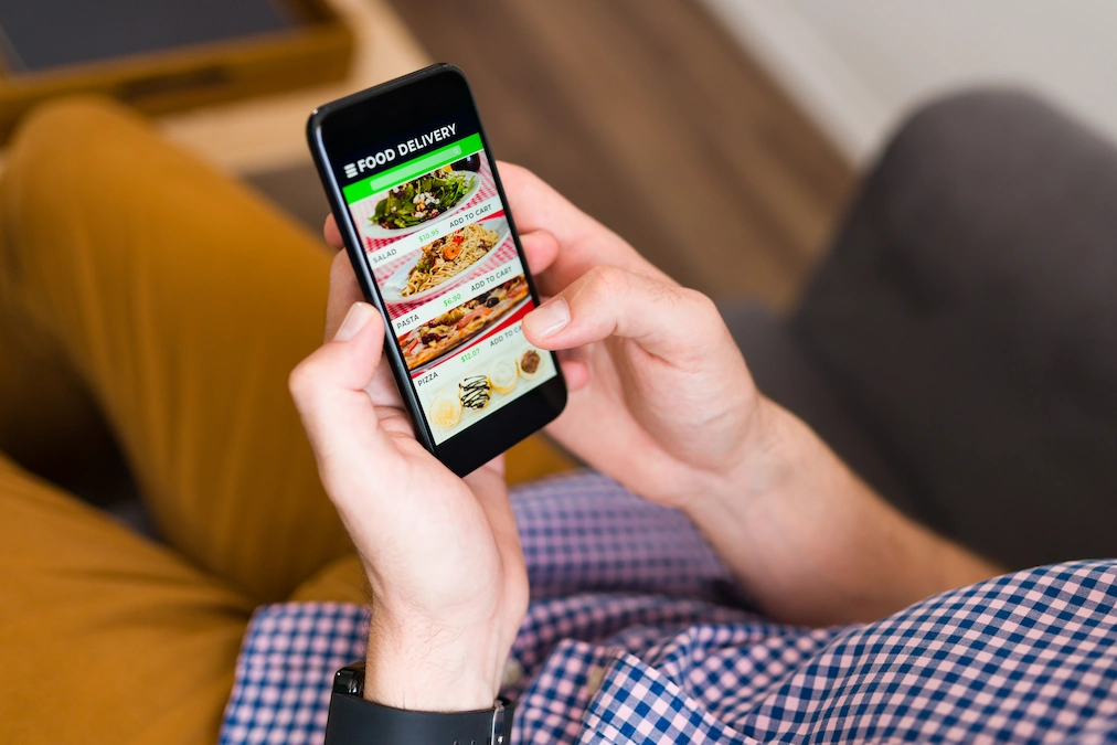 man looking food delivery app his smartphone ordering dinner online
